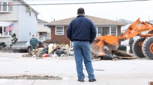 A guy looking at a demolition across his street