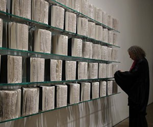 screenshot of The Liberation of Helene Aylon with an old woman looking at some files.