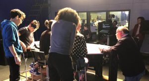 On-air talent coach Lennart Bourin, right, working with students in Prof. Sissel McCarthy’s studio news class.